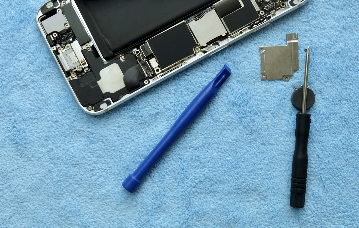 Person Repairing Smartphone with A Screwdriver